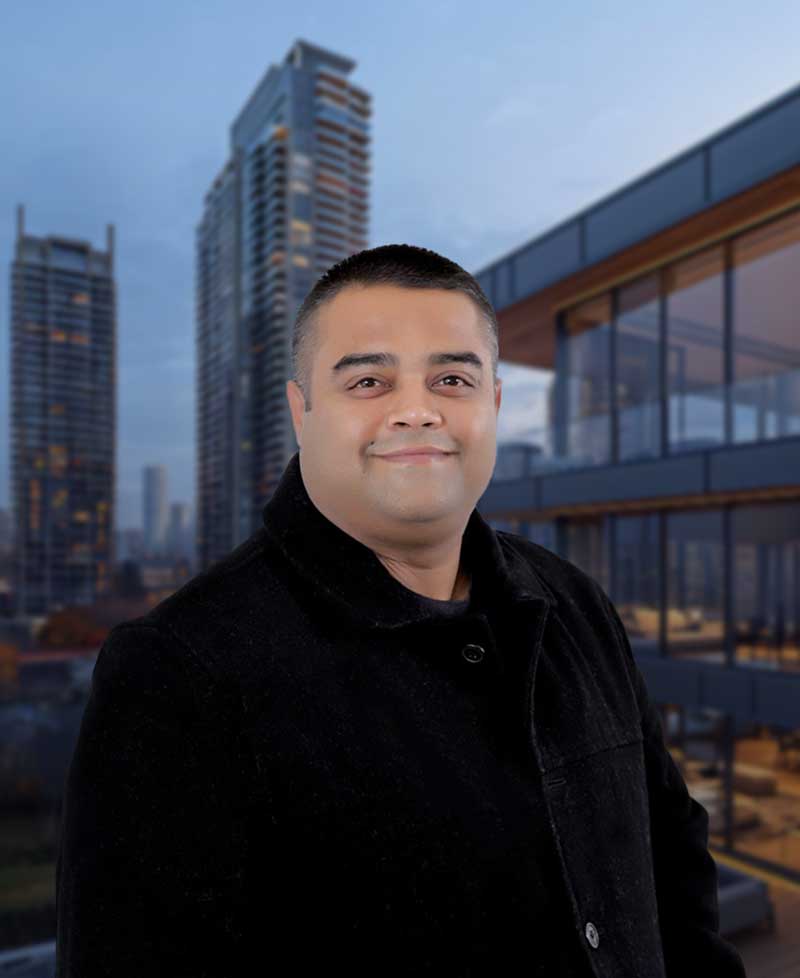 Kunal Nijhawan, Metro Vancouver real estate agent, standing in front of modern residential buildings